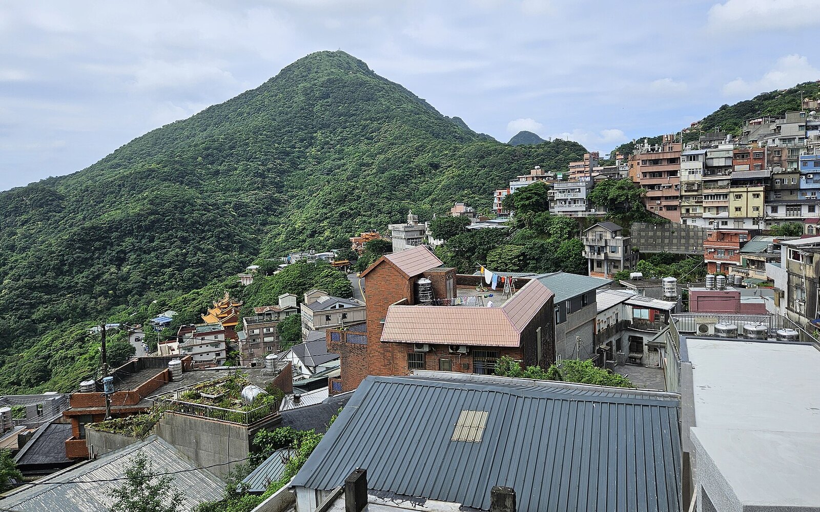 基隆山の緑と斜面に折り重なる九份の家並み