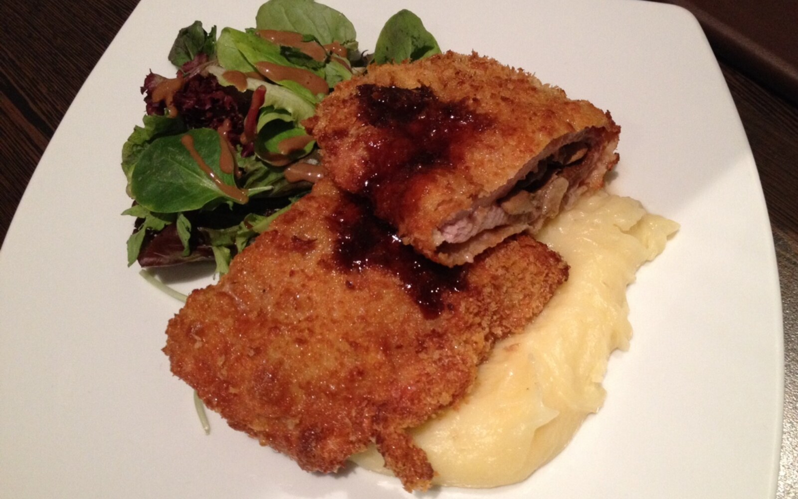 衣をつけて揚げた豚肉のシュニッツェルをマッシュポテトとサラダに添えた一皿