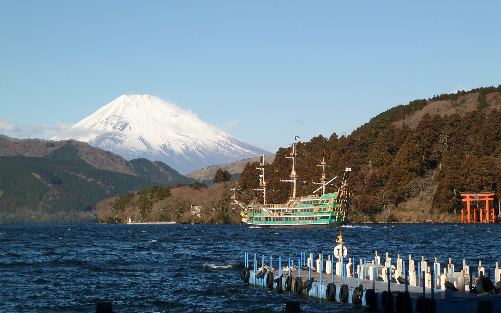 芦ノ湖の湖面越しに望む富士山と観光船、箱根神社の鳥居
