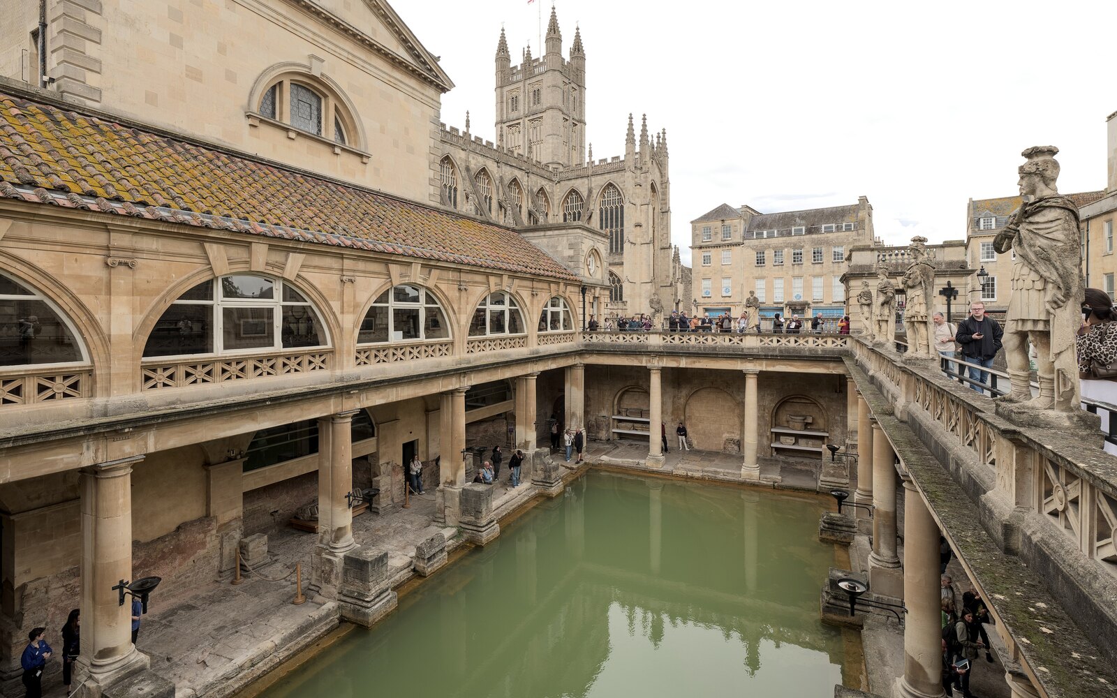 緑色の大浴槽を囲むローマン・バスの列柱と、その奥に立つバース寺院